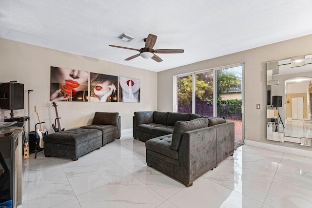 living room with visible vents, marble finish floor, baseboards, ceiling fan, and arched walkways