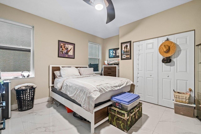 bedroom featuring a closet, marble finish floor, and ceiling fan