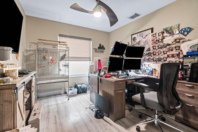office space with visible vents, a ceiling fan, and light wood finished floors