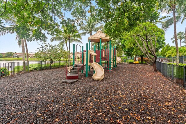 community playground featuring a water view and fence