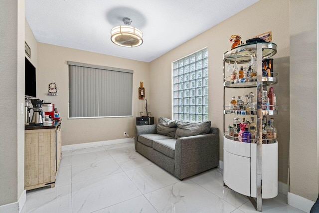 living room featuring baseboards and marble finish floor