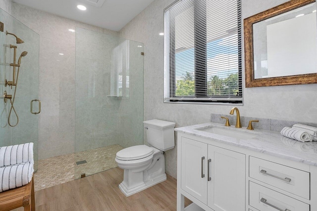 bathroom featuring wood-type flooring, vanity, toilet, and an enclosed shower