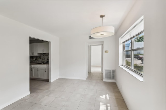 empty room featuring sink and light tile patterned floors