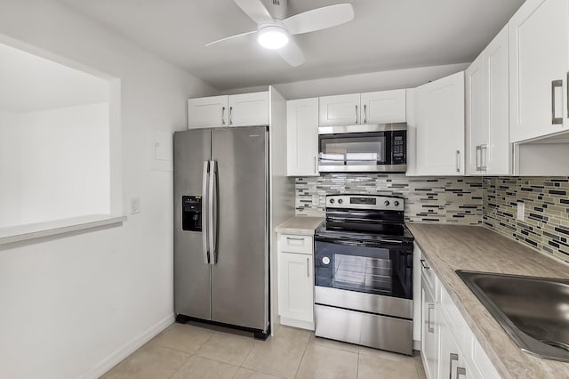 kitchen with white cabinets, backsplash, stainless steel appliances, light tile patterned flooring, and ceiling fan