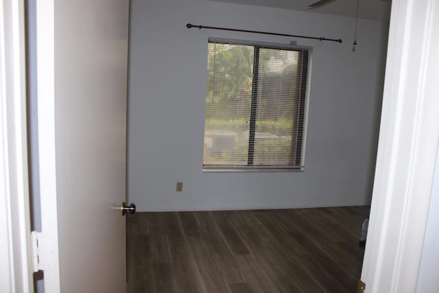 unfurnished room with ceiling fan, dark wood-type flooring, and a healthy amount of sunlight