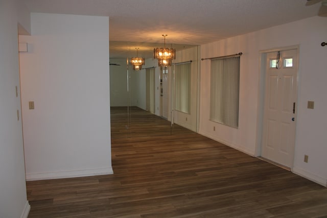 interior space with a textured ceiling and dark wood-type flooring