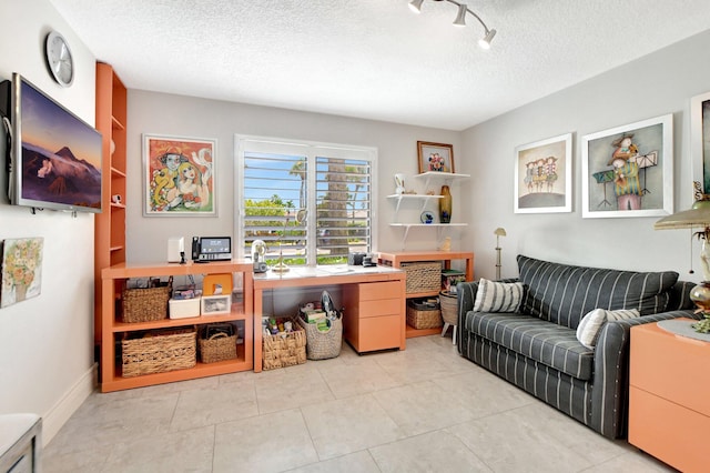 home office with a textured ceiling, rail lighting, and light tile patterned flooring