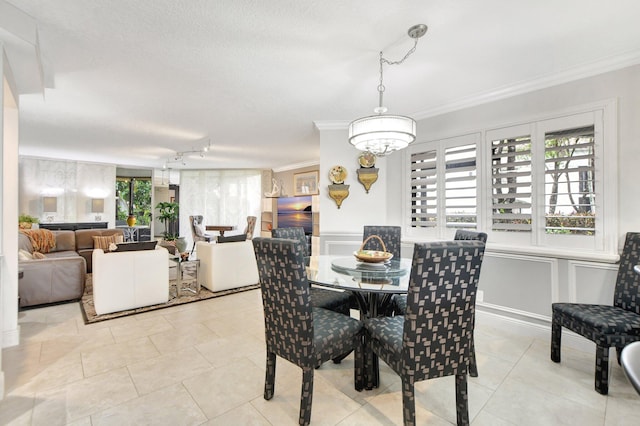 dining room with light tile patterned floors, a wealth of natural light, a textured ceiling, and ornamental molding