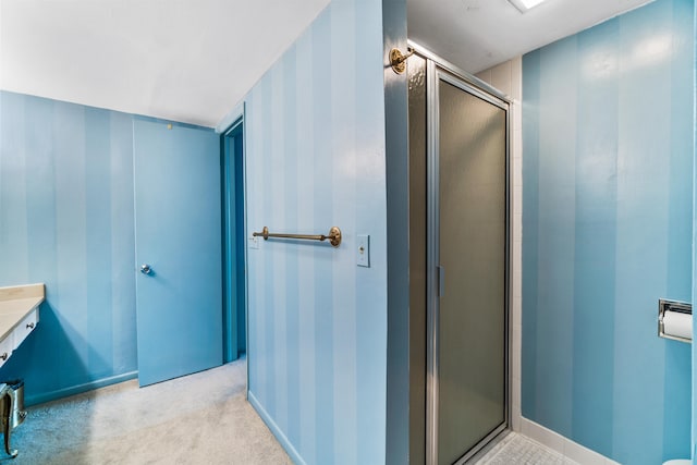 bathroom with a shower with door and vanity