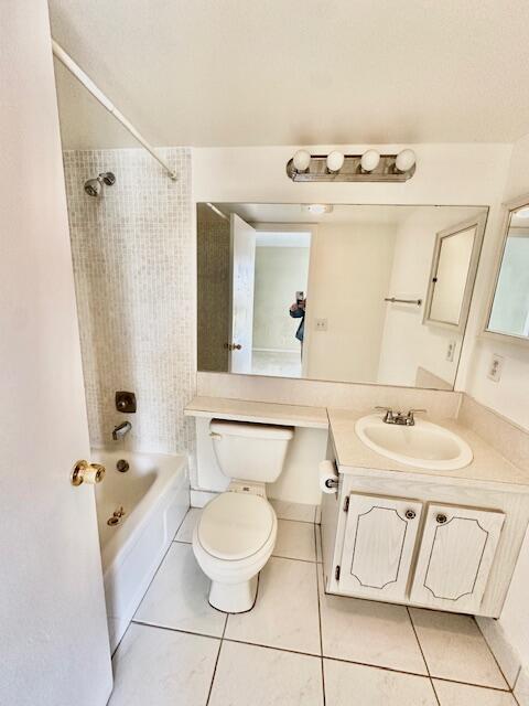 full bathroom featuring vanity, toilet, tiled shower / bath combo, and tile patterned flooring