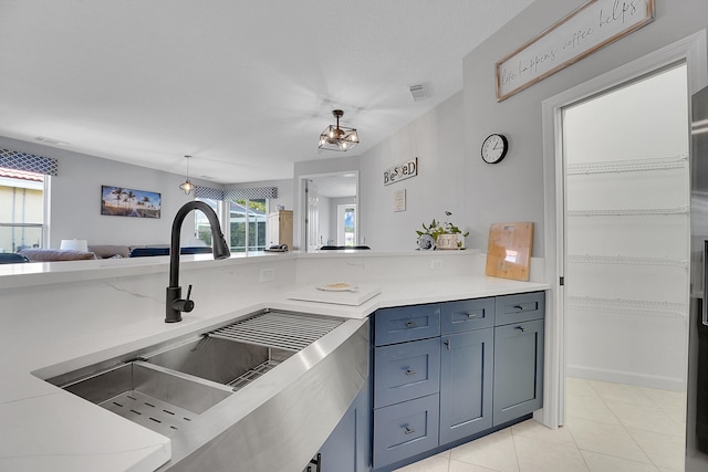 kitchen featuring light tile patterned floors, decorative light fixtures, and sink