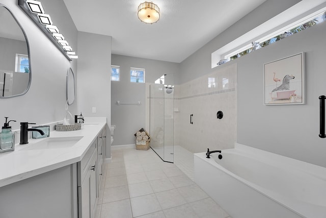 bathroom with tile patterned flooring, vanity, and separate shower and tub