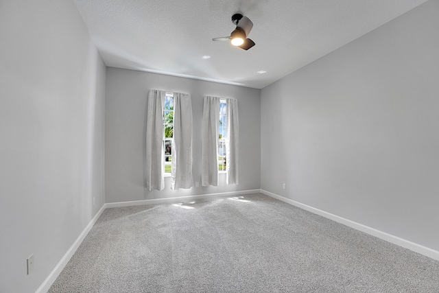 carpeted empty room featuring a textured ceiling and ceiling fan