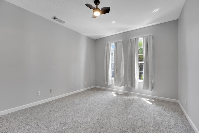 carpeted empty room featuring a textured ceiling and ceiling fan