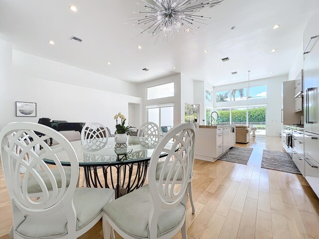 dining room with light hardwood / wood-style flooring and a notable chandelier