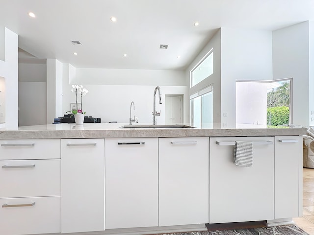 kitchen featuring dishwasher, sink, and white cabinets