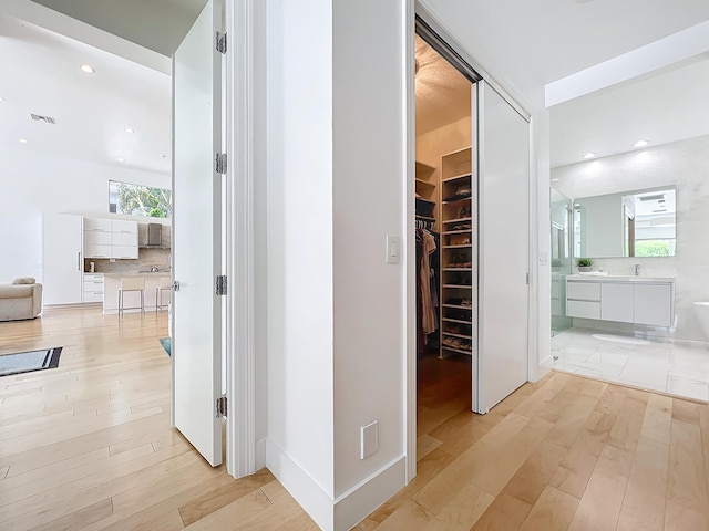 hallway with light hardwood / wood-style flooring and a healthy amount of sunlight