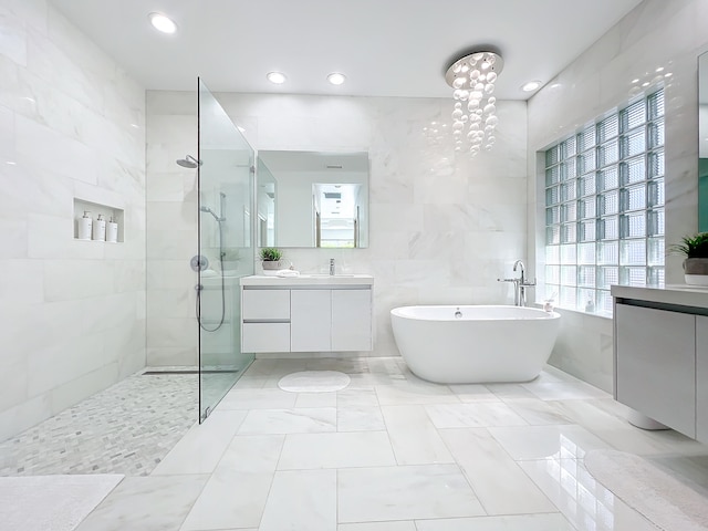 bathroom featuring vanity, plus walk in shower, and tile walls