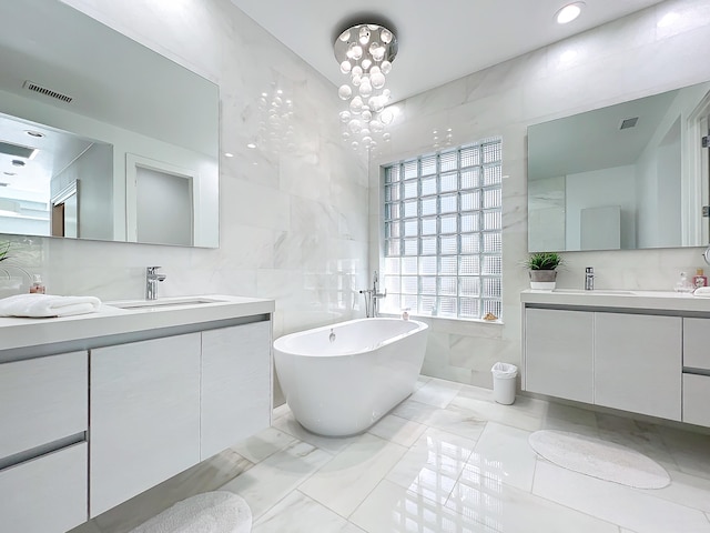 bathroom with a bath, tile walls, vanity, and a chandelier