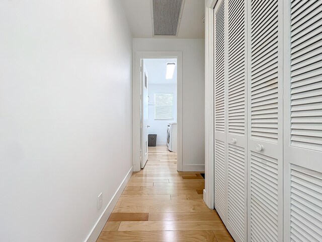 hallway featuring light wood-type flooring and washer / dryer