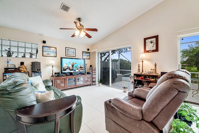 tiled living room with ceiling fan, lofted ceiling, and a healthy amount of sunlight