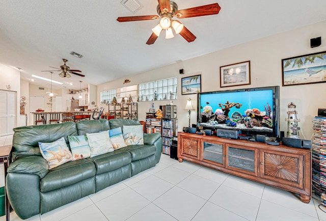 tiled living room featuring lofted ceiling, ceiling fan, and a textured ceiling