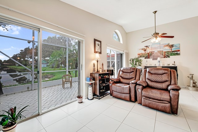 living room with light tile patterned floors, lofted ceiling, ceiling fan, and plenty of natural light