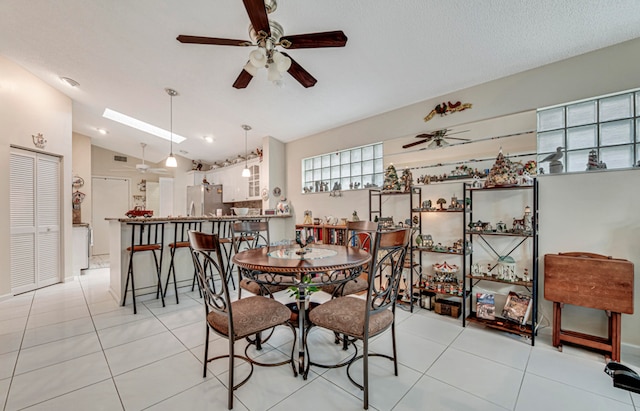 dining area with ceiling fan, a textured ceiling, lofted ceiling, and light tile patterned floors