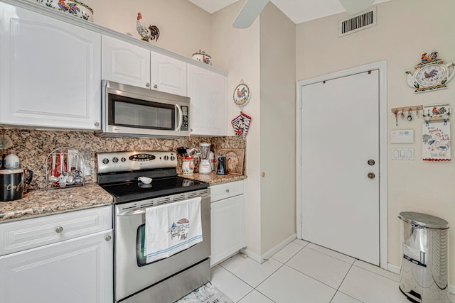 kitchen featuring decorative backsplash, light stone counters, stainless steel appliances, and white cabinets