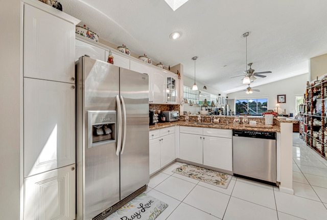 kitchen with ceiling fan, white cabinets, light tile patterned floors, appliances with stainless steel finishes, and vaulted ceiling