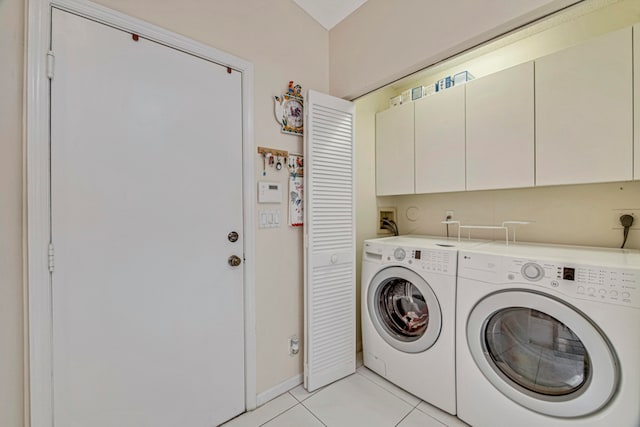 laundry room featuring cabinets, light tile patterned floors, and washing machine and clothes dryer