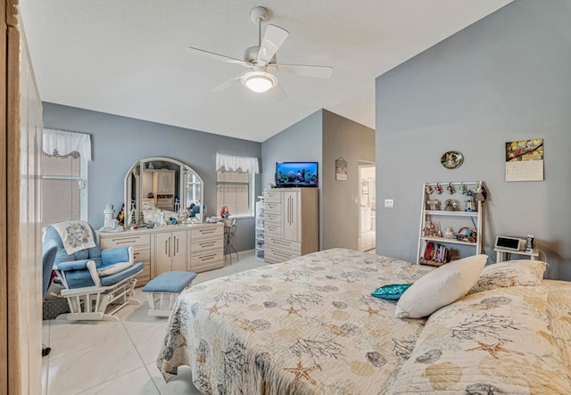 bedroom featuring light tile patterned floors, vaulted ceiling, and ceiling fan