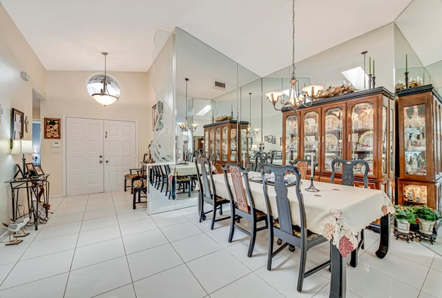 dining space with an inviting chandelier, high vaulted ceiling, and light tile patterned flooring