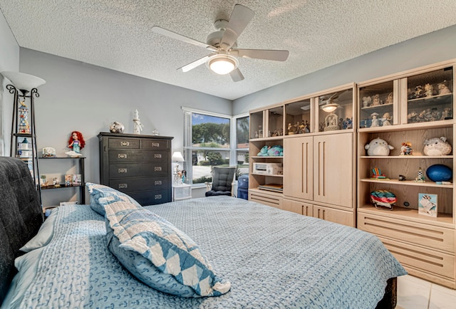 bedroom with ceiling fan and a textured ceiling