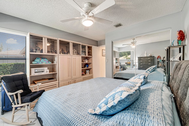 bedroom with a closet, ceiling fan, and a textured ceiling