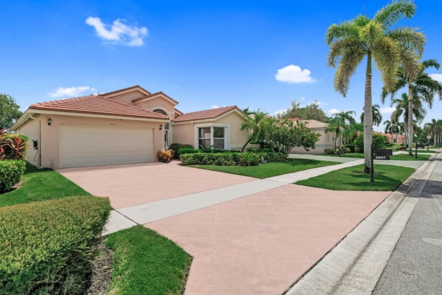 mediterranean / spanish-style home with a front yard and a garage