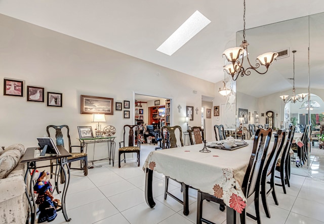 tiled dining room with vaulted ceiling with skylight and an inviting chandelier