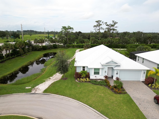 view of front of house featuring a garage, a front yard, and a water view