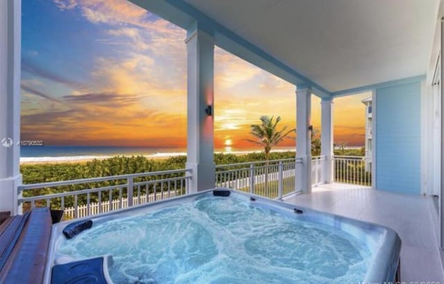 pool at dusk with an outdoor hot tub