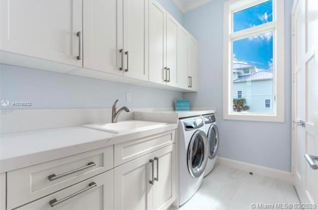 washroom featuring cabinets, sink, and washer and clothes dryer