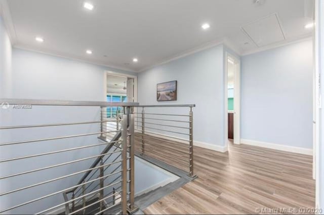 corridor with wood-type flooring and crown molding