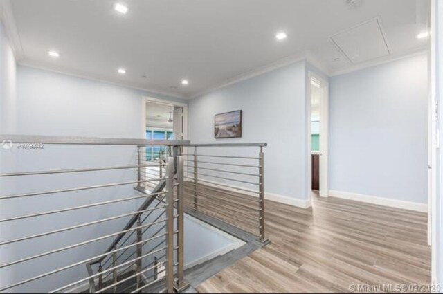 interior space with baseboards, recessed lighting, an upstairs landing, attic access, and crown molding