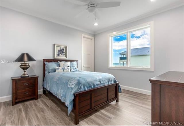 bedroom featuring light hardwood / wood-style floors, crown molding, and ceiling fan