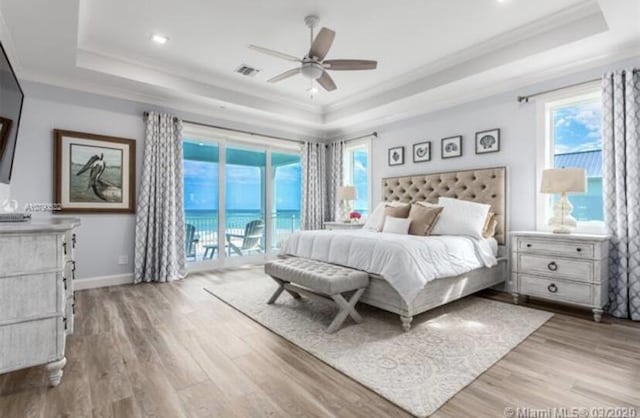bedroom featuring ornamental molding, access to exterior, a raised ceiling, and visible vents