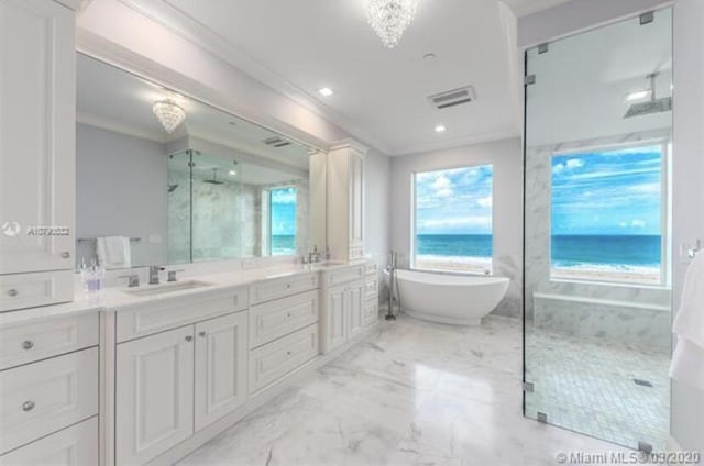 full bath featuring a freestanding tub, double vanity, ornamental molding, a marble finish shower, and a sink