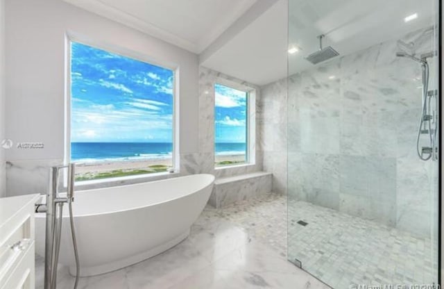 bathroom with a freestanding bath, vanity, marble finish floor, and a marble finish shower