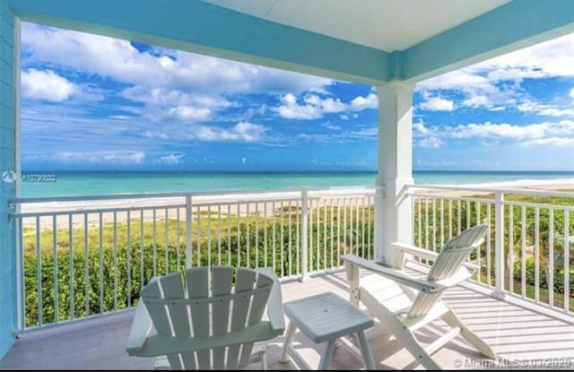 balcony with a view of the beach and a water view