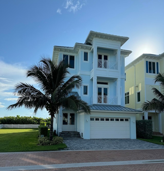 view of front of property featuring a front yard, a balcony, and a garage