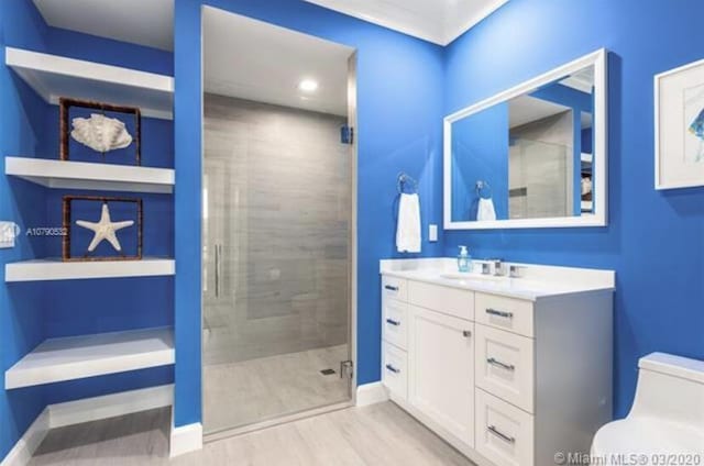 bathroom featuring a shower stall, wood finished floors, baseboards, and toilet
