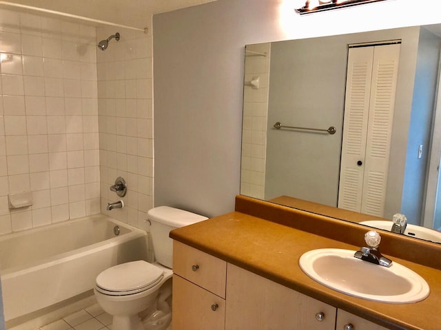 full bathroom featuring vanity, toilet, tiled shower / bath combo, and tile patterned floors